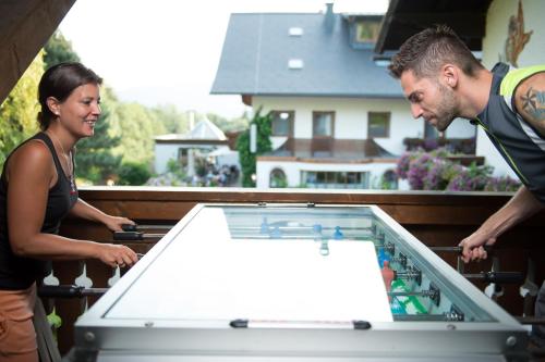 a man and a woman looking at a pool table at Pension Irlingerhof in Mondsee