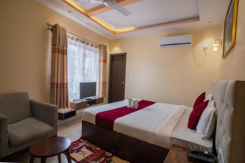 a bedroom with a bed and a chair and a window at Hotel Ozone 24 in Butwāl