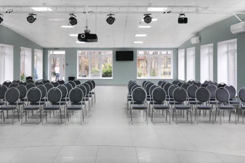 a large room with chairs and a person standing in the background at Kohavi Forest Club in Orlovshchina