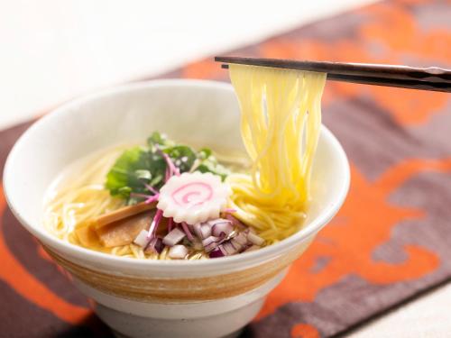 a bowl of noodle soup with noodles and chopsticks at Miyakonojo Green Hotel in Miyakonozyō