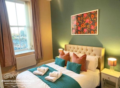 a bedroom with a large bed with towels on it at Apartment 1 West County by Prestige Properties SA in Millom