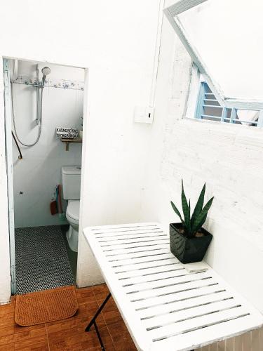 a white bench in a bathroom with a toilet at Samstay in Tuy Hoa