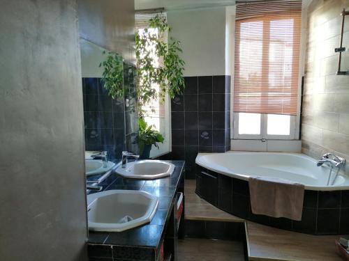 une salle de bain avec deux lavabos et une baignoire dans l'établissement BELLE MAISON DE CARACTERE Dans VILLAGE et sa PISCINE Privée 7 PERS- 3 Chambres - 12 Rue Emile Zola, à Millas