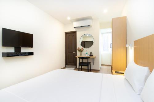 a hotel room with a bed and a television at Sanctum Suites Richmond Road Bangalore in Bangalore