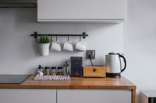 a kitchen counter with mugs hanging on a wall at Little House JFK AIRPORT in Brooklyn Manor