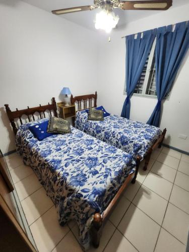 1 Schlafzimmer mit 2 Betten und blauer Decke in der Unterkunft Departamento El Parral Parque Central in La Cieneguita