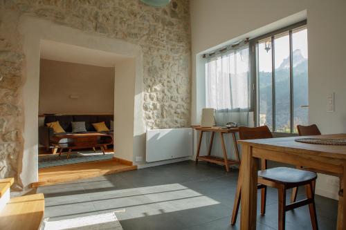 une chambre avec une table et des chaises ainsi qu'un salon dans l'établissement La tête dans les nuages et les pieds dans l'eau, à Saint-Benoît-en-Diois