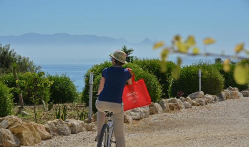 a person riding a bike with a red bag at Tenute Plaia Agriturismo in Scopello