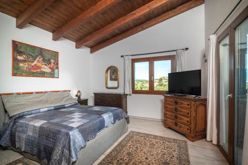 - une chambre avec un lit et une télévision à écran plat dans l'établissement Residenza del golfo, à Telti
