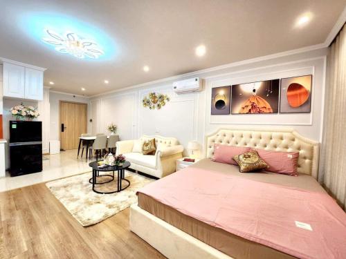 Homestay HaLong studio في ها لونغ: غرفة نوم مع سرير وغرفة معيشة