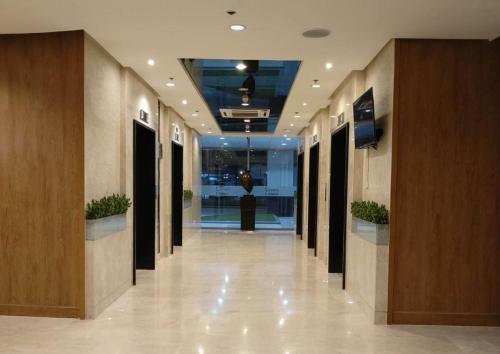 a hallway of an office building with columns and plants at Shore Residences MOA Dynastel Staycation in Manila