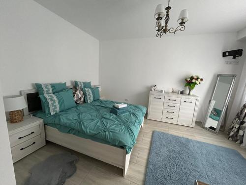 a bedroom with a bed and a dresser and a mirror at Studio G&A Hunedoara Apartment in Hunedoara