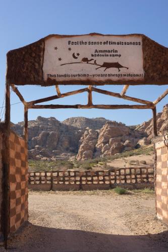 a sign in the desert with mountains in the background at Ammarin Bedouin Camp in Wadi Musa
