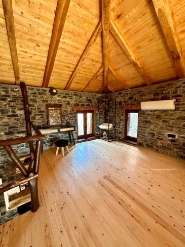 a large room with a wooden floor and wooden ceilings at Black Rock Agria in Agria