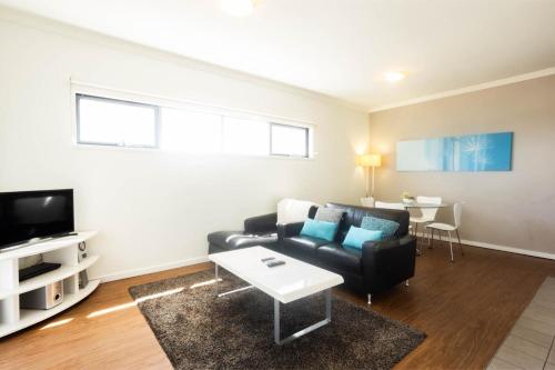 a living room with a couch and a table at Lovely 2BR Apartment in West Perth with Parking! in Perth