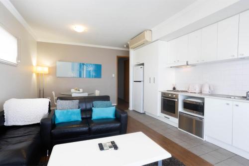 a living room with a couch and a kitchen at Lovely 2BR Apartment in West Perth with Parking! in Perth