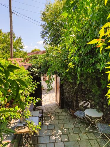 a garden with a table and chairs and trees at Roptro in Doliana