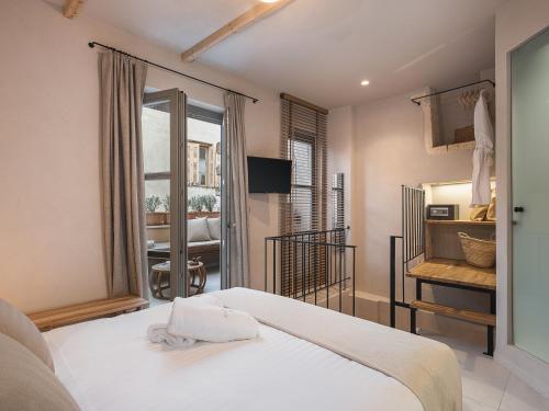Un dormitorio con una cama blanca y una ventana. en Casa Athanasia, en La Canea