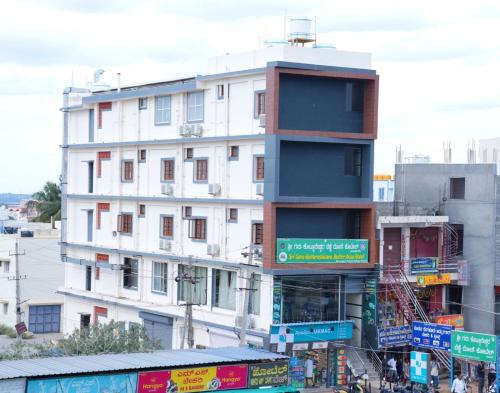 un edificio blanco alto con señales delante en Dayanand Residency, en Chitradurga