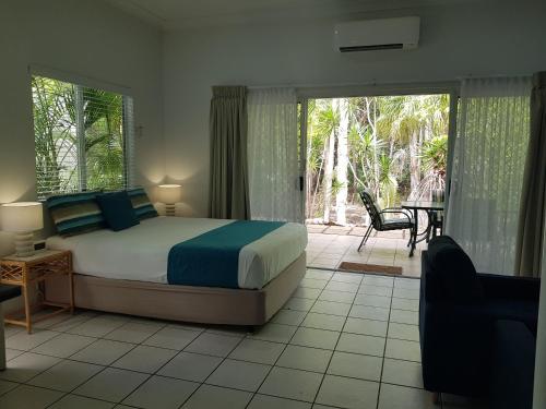 - une chambre avec un lit et une terrasse avec une table dans l'établissement Coral Suite in Resort Complex, à Agnes Water