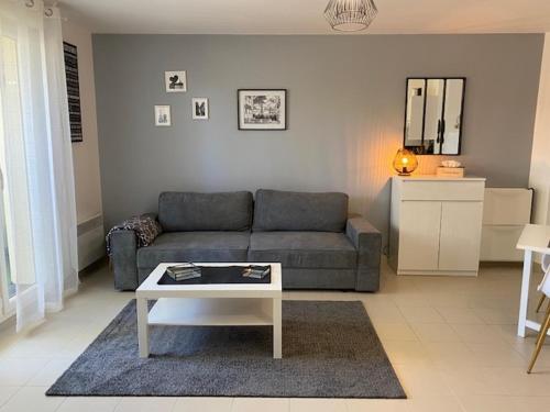 un salon avec un canapé et une table dans l'établissement Aux portes de Paris, à Limay