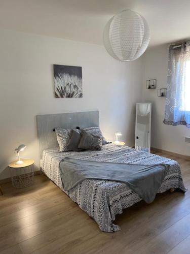 - une chambre avec un lit doté d'une couverture bleue dans l'établissement Aux portes de Paris, à Limay