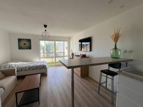 錫富爾勒普拉日的住宿－Studio 35m2, 500m de la plage + parking gratuit.，客厅配有一张床和一张桌子