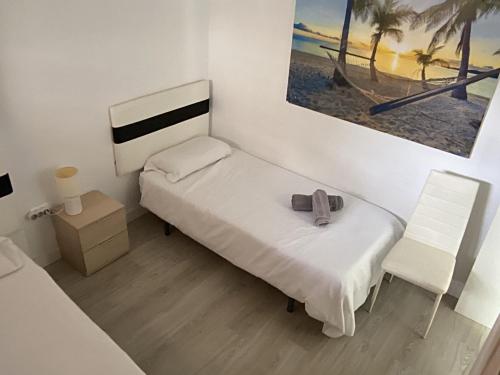 niewielka sypialnia z łóżkiem i krzesłem w obiekcie Casa Torremar Playa de San Juan w Alicante