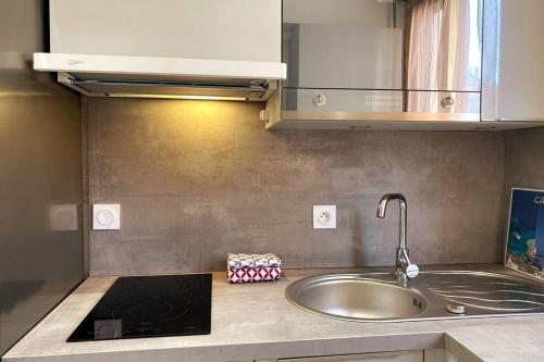 Il comprend une cuisine équipée d'un évier et d'une cuisinière. dans l'établissement St Raphaël centre calme clim mer commerces à pieds, à Saint-Raphaël