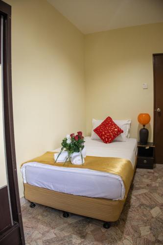 a bedroom with a bed with flowers on it at Sweet Inn Guest House in Kuantan
