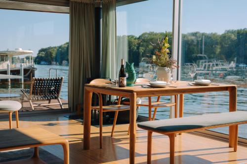 une salle à manger avec une table, des chaises et une grande fenêtre dans l'établissement JULIA - Schwimmendes Apartment, à Berlin