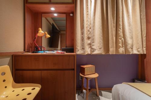 a bedroom with a bed and a mirror and a chair at Aank Ryokan Yosuriguri Cheonan in Cheonan