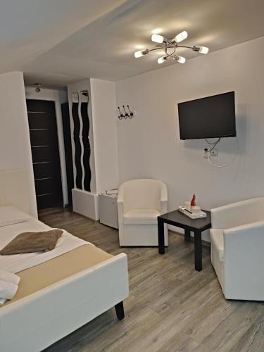 a living room with two beds and a flat screen tv at D&D Busteni in Buşteni
