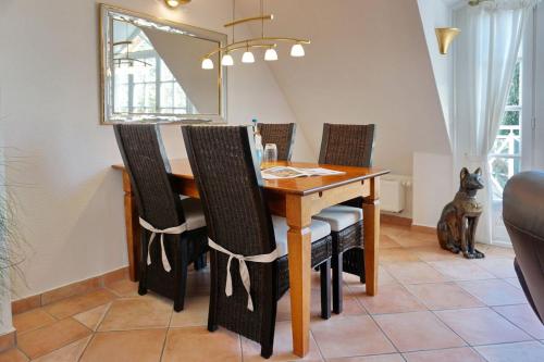 uma mesa de jantar com cadeiras e um espelho em Landhaus Normannenweg App 4D em Wenningstedt