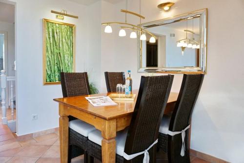 uma mesa de jantar com cadeiras e um espelho em Landhaus Normannenweg App 4D em Wenningstedt