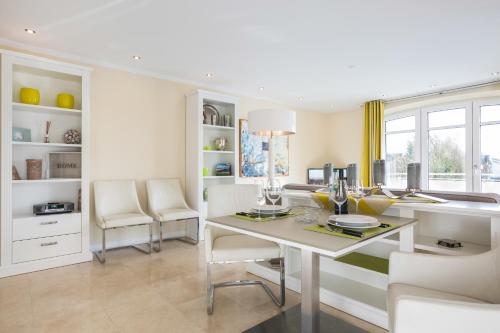 une salle à manger blanche avec une table et des chaises dans l'établissement Nette Sun App 10, à Westerland