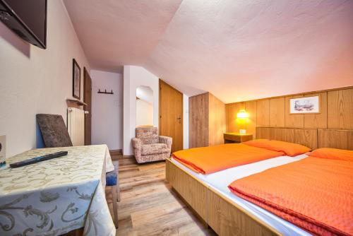 um quarto com uma cama e uma cadeira em Gasthof Anny em Marlengo
