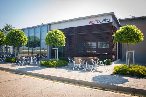 a group of tables and chairs in front of a building at AeroCafe in Partizánske