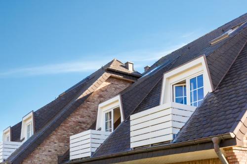 dom z czarnym dachem i białymi oknami w obiekcie Wendinghues App 7 w mieście Wenningstedt