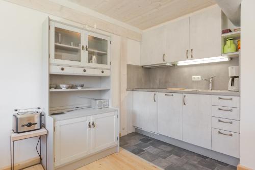 a kitchen with white cabinets and a sink at Friesenhaus Birkenhof in Westerland (Sylt)