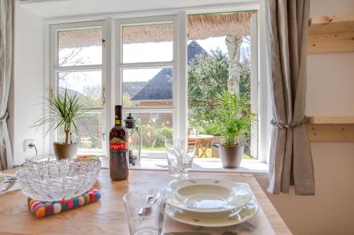 a table with glasses and a bottle of wine and a window at Friesenhaus Birkenhof in Westerland (Sylt)