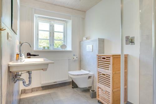a white bathroom with a sink and a toilet at Friesenhaus Birkenhof in Westerland (Sylt)