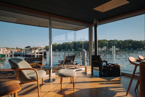 een veranda met stoelen en uitzicht op het water bij JULIA - Schwimmendes Apartment in Berlijn