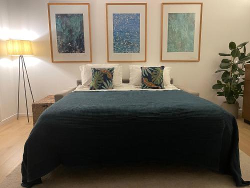 ein Schlafzimmer mit einem großen schwarzen Bett mit zwei Kissen in der Unterkunft Luxury Top Floor Apartment with terrace - Beaulieu Sur Mer in Beaulieu-sur-Mer