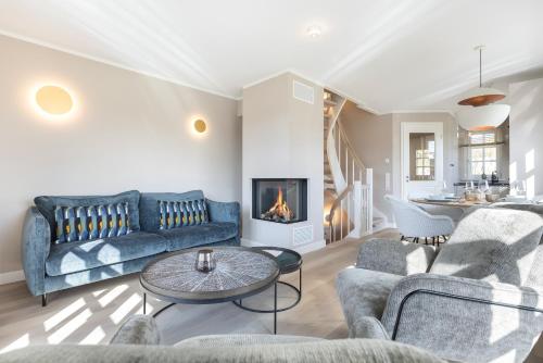 a living room with a couch and a fireplace at Lille Wung in Wenningstedt