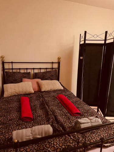 ein Bett mit zwei roten Kissen darüber in der Unterkunft Fagersta Apatrtment in Fagersta