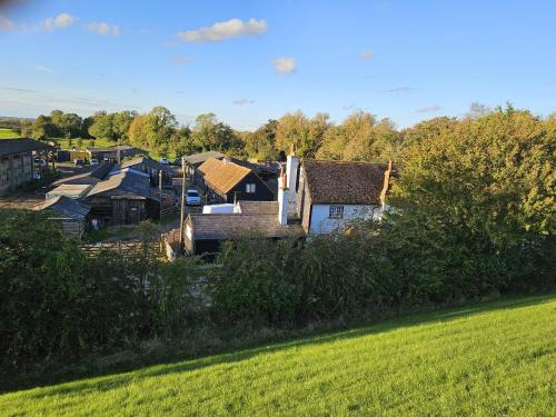 Startop Farmhouse في Marsworth: مجموعة منازل في حقل بجانب حقل أخضر