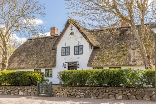 a white house with a thatched roof at Kampende II in Tinnum