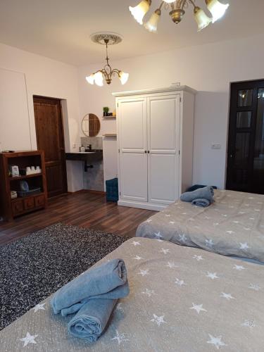 a bedroom with two beds and a white cabinet at Pannónia Rooms and Apartments in Satu Mare