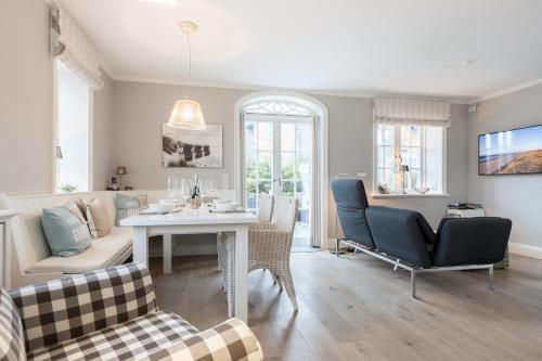 ein Wohnzimmer mit Tisch und Stühlen in der Unterkunft Haus Seaside in Wenningstedt-Braderup